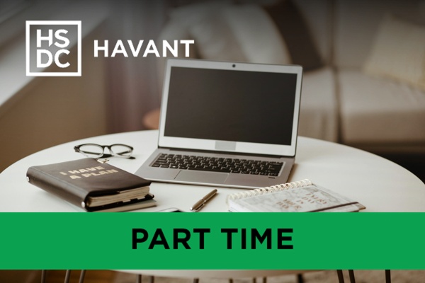 laptop with a planner and a notepad on a small table