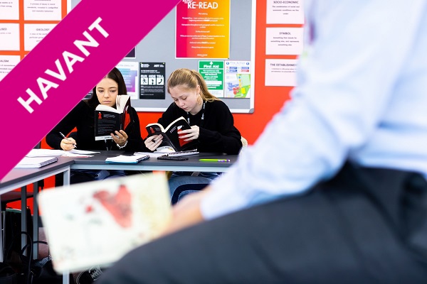 two female students reading books in class