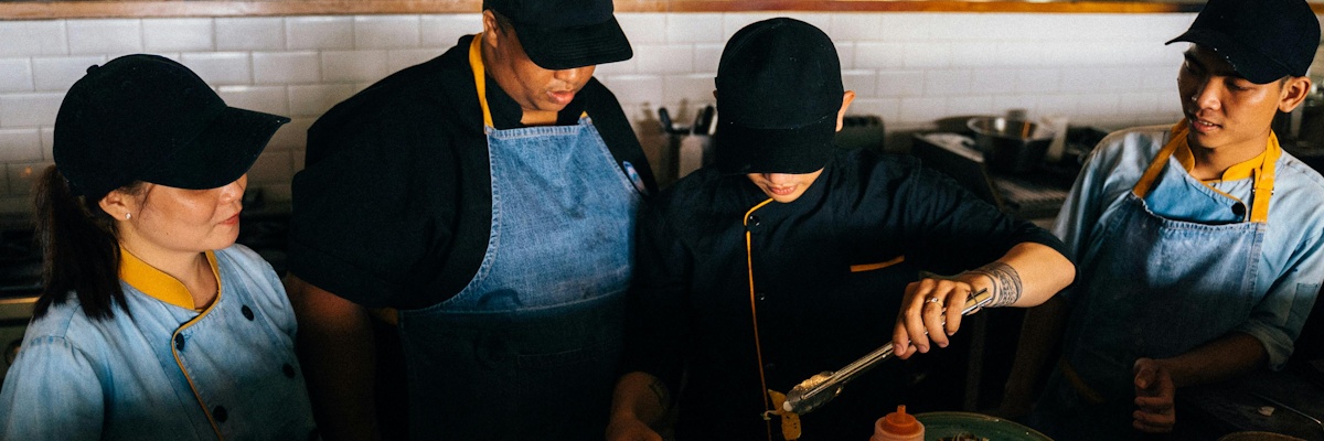 A food and beverage team working on a dish together.