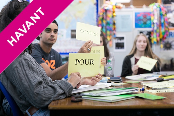 students holding up French words in class