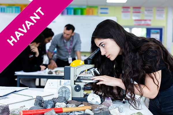 a student looking through a microscope