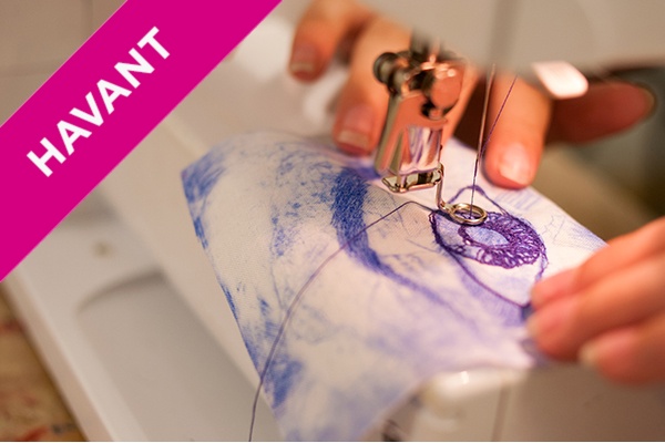 a textiles student works on an embroidery of an eye.