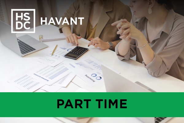 two accounting students working on laptops and a calculator.