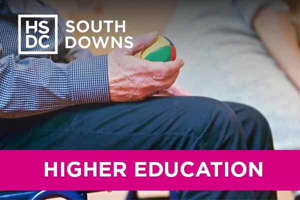 An elderly gentleman doing physical therapy with a ball.