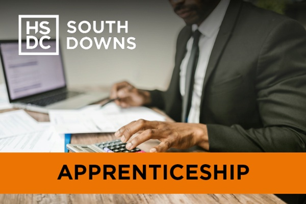 a man in a suit doing accountancy work with a laptop and a calculator