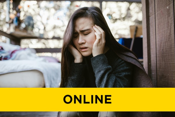 a girl in distress sitting against a wall