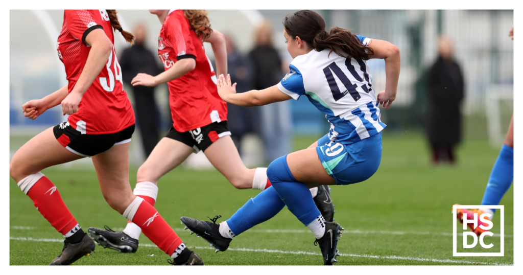 Student footballer Libby Hester tackling another player.