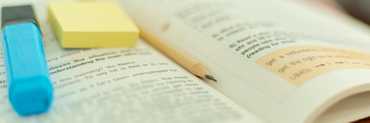 A piece of English text with highlighted segments, a highlighter and a pencil.
