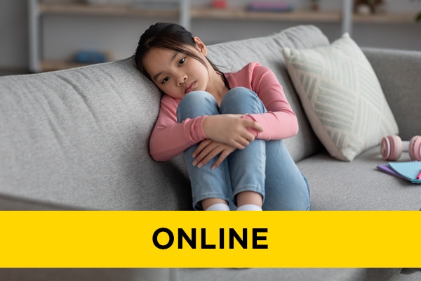 A sad looking child hugging their knees.