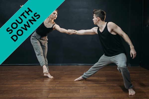Two dancers learning choreography in a studio.