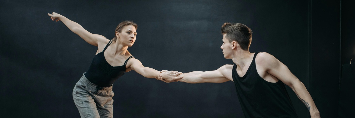 Two dancers learning choreography in a studio.
