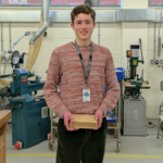 a student holding a wooden box