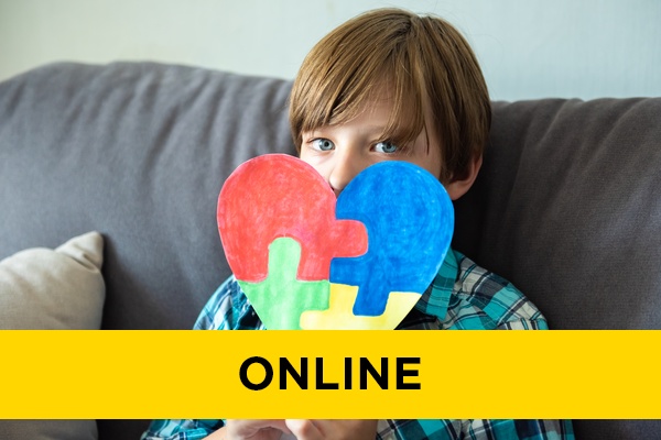 A child holding up a colourful jigsaw in a heart shape.