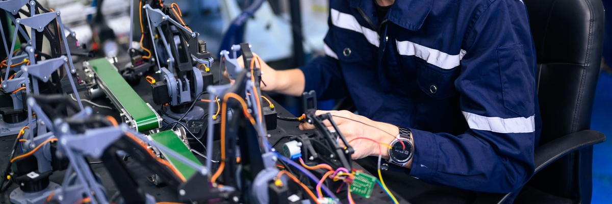 A man working on a robotic system in a factory.