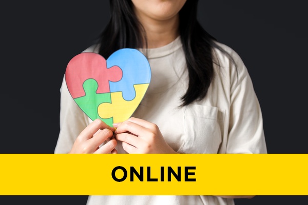 A woman holding a colourful heart-shaped jigsaw.