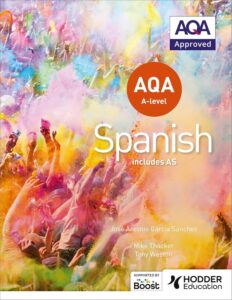 The Spanish AQA A Level text book. It is by Hodder Education and approved by AQA. The cover shows a group of people celebrating in a colour festival.